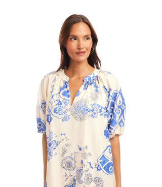 Woman wearing a blue and white patterned blouse on a white background