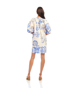 Woman wearing a floral dress with blue patterns on a white background