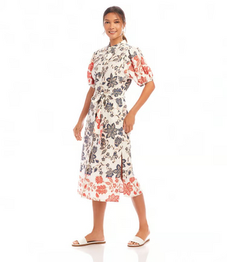 A woman wearing a floral shirtdress with puff sleeves, collar, and a removable fabric belt.
