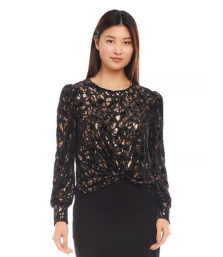 A woman wearing a black and copper, puff sleeve top with a cheetah print and metallic foil detail.