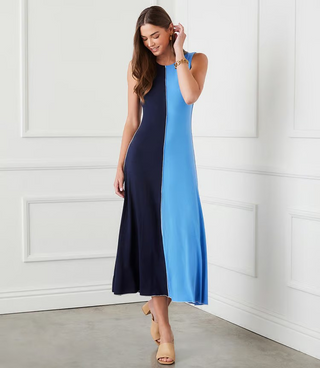A sleeveless midi dress with color blocking in navy and blue, worn by a model standing against a white background.