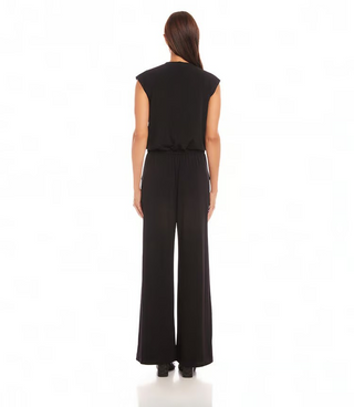 A woman modeling a sleeveless black jumpsuit with a V-neck and wide-leg pants.