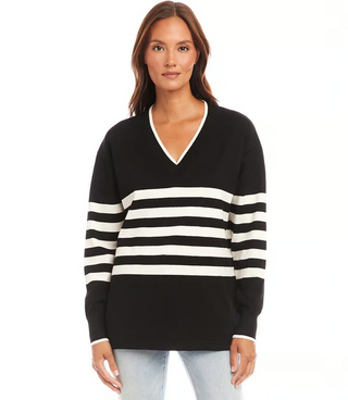 A woman wearing a striped V-neck sweater with long sleeves, in a pattern of black and white horizontal stripes.