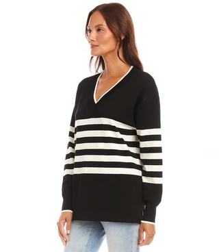 A woman wearing a striped V-neck sweater with long sleeves, in a pattern of black and white horizontal stripes.