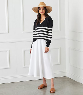 A woman wearing a striped V-neck sweater with long sleeves, in a pattern of black and white horizontal stripes.