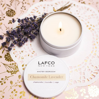 LAFCO Chamomile Lavender 4 oz Travel Tin Candle with open lid styled next to lavender.