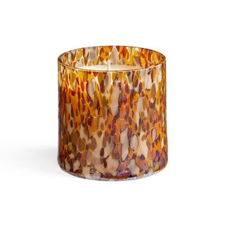 A hand-blown glass candle vessel with a multicolored pattern containing a LAFCO Labdanum Absolute fragrance candle.