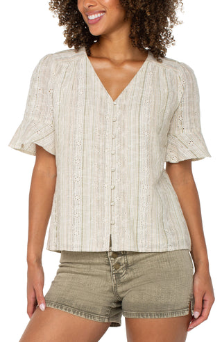 A woman wearing a green and tan striped elbow peplum sleeve crossover woven top with short sleeves, paired with beige shorts.