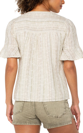 A woman wearing a green and tan striped elbow peplum sleeve crossover woven top with short sleeves, paired with beige shorts.