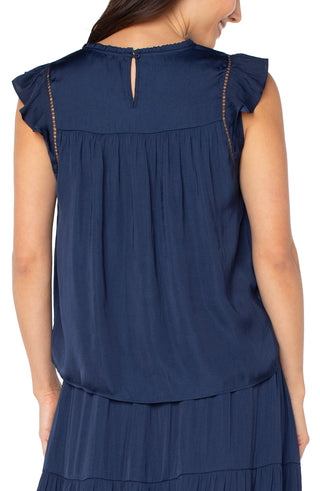Navy blue sleeveless top worn by a person on a white background