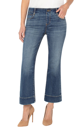 Blue jeans with hem detail worn by a person on a white background