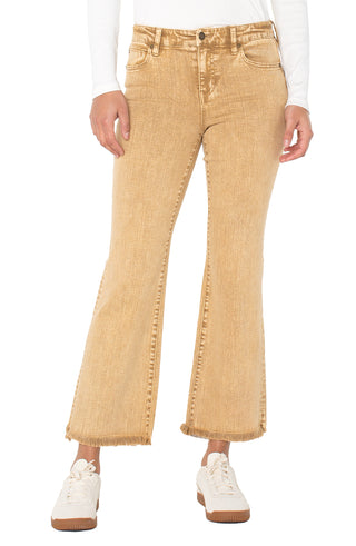 Beige flared jeans worn by a person on a white background