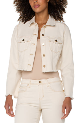 A woman wearing a beige Liverpool jacket with fray hem, paired with a white top and white jeans.