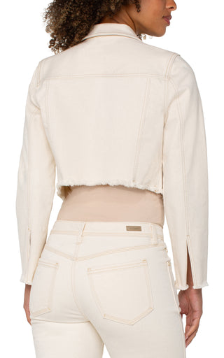 A woman wearing a beige Liverpool jacket with fray hem, paired with a white top and white jeans.