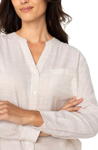 A long sleeve button front woven shirt with a banded collar in a light tan and white color combination.