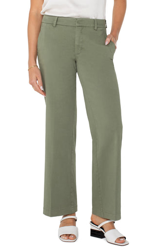 A pair of olive green wide leg Kelsey trousers with a structured waistband, paired with a white top and white sandals.