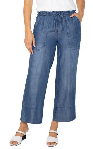 A pair of Liverpool brand wide leg pants with a tie waist and a detailed hem, in a blue denim wash.