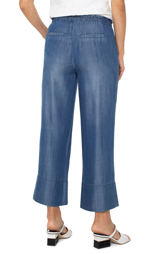A pair of Liverpool brand wide leg pants with a tie waist and a detailed hem, in a blue denim wash.