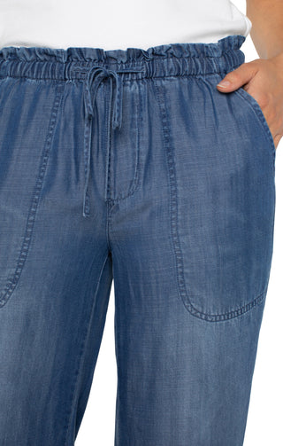 A pair of Liverpool brand wide leg pants with a tie waist and a detailed hem, in a blue denim wash.