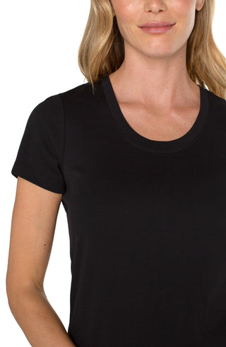 A model wearing a Liverpool scoop neck tee in black with a medium wash denim jean.