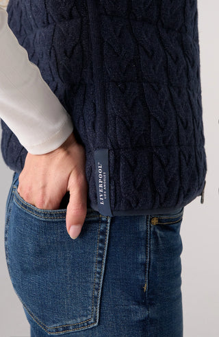 Liverpool Sleeveless Reversible Quilted Sweater Vest in Heather Navy
Close-up of a person wearing a dark 
navy cable-knit zip-front vest over a white long-sleeve top and blue jeans, with a small vertical Liverpool label visible at the side seam.
