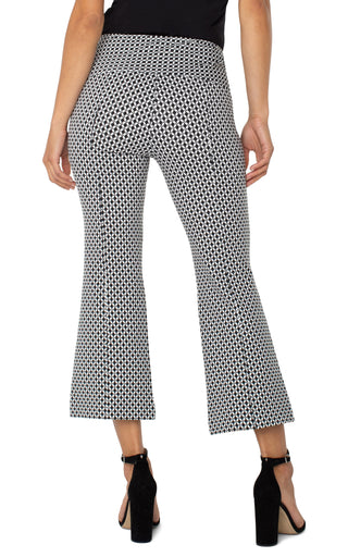 A pair of black and white batik print flare pants with welt pockets and a mid-rise waist.
