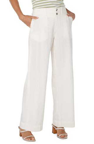 A pair of wide leg, cream-colored utility pants with patch pockets and a button fly closure.