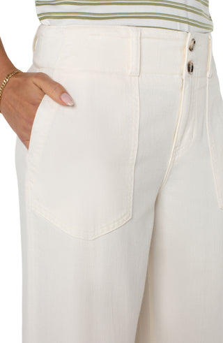 A pair of wide leg, cream-colored utility pants with patch pockets and a button fly closure.
