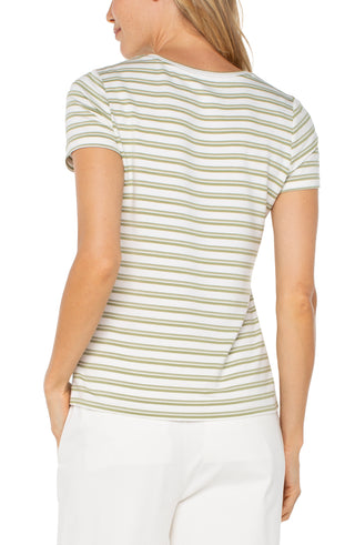 A woman wearing a striped crew neck knit tee in green and cream colors, paired with white pants.