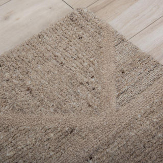 Lofton 7'9"x9'9" Rug in Brown
A rectangular area rug with a geometric pattern of interlocking triangles and rectangles in shades of taupe, beige, and brown, showing a textured woven surface.