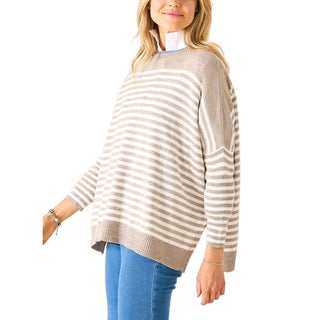 Woman wearing a beige and white striped sweater with blue jeans on a white background. Mersea Catalina Modern Crew Sweater in Driftwood