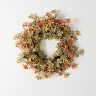 Autumn-themed wreath with leaves and berries on a white background