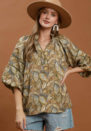 Mix Botanical Print Puff Sleeve Blouse in Olive Mix
A woman wearing a loose,  3/4 length sleeve blouse with a brown, beige, and gray paisley pattern, green leaf