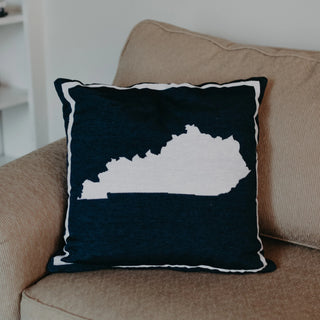 A square-shaped throw pillow with the tapestry material, featuring the navy state of Kentucky shape in white. Navy Kentucky State Pillow