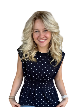 Woman wearing a navy blue top with white polka dots
