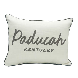 A rectangular white throw pillow with the text 'Paducah Kentucky' printed in a curved script design in gray color, with a solid pattern and gray piping on the edges.