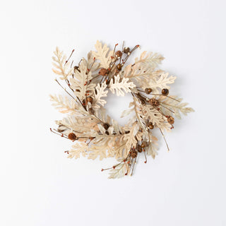 Decorative wreath with beige leaves and small brown berries on a white background