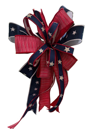 Decorative bow with red, white, and blue colors on a green wreath.