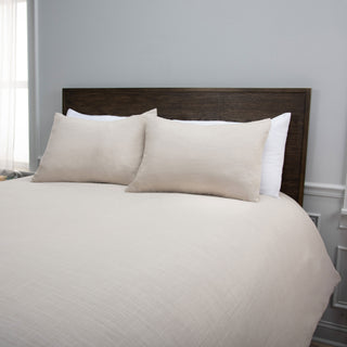 Rizzy Blackberry Grove Comforter Set in Natural
Beige textured bedding set on a bed with a dark wood headboard, featuring two beige shams linen natural
