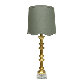 Table lamp with gold base and gray shade on a white background