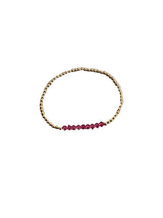 Bracelet with gold and pink beads on a white background