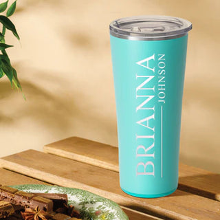 A blue stainless steel SWIG tumbler with a clear lid and a silicone base.