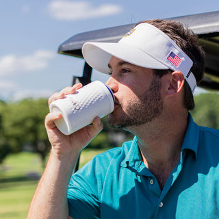 Man drinking from the SWIG Golf Ball Can Bottle Cooler 12 oz