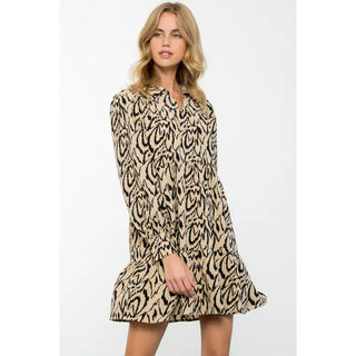 Woman wearing a THML beige and black patterned dress on a white background