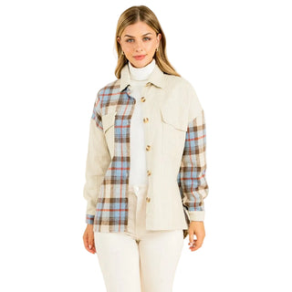 A woman modeling a long-sleeve button-front overshirt with a cream ribbed body and plaid sleeves in beige, brown, and light blue, worn over a white turtleneck and white pants against a plain light beige studio background. THML Mixed Media Button Up Jacket