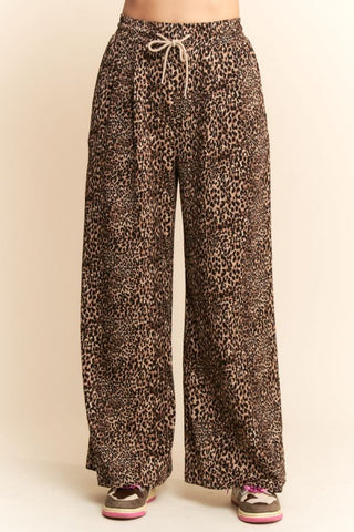 Leopard print pants with a drawstring waist on a beige background. Taupe Leopard Printed Wide Leg Pants