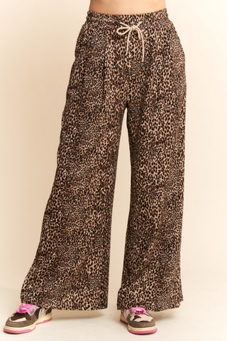 Leopard print pants with a drawstring waist on a beige background. Taupe Leopard Printed Wide Leg Pants