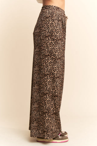 Leopard print pants worn by a person on a beige background. Taupe Leopard Printed Wide Leg Pants