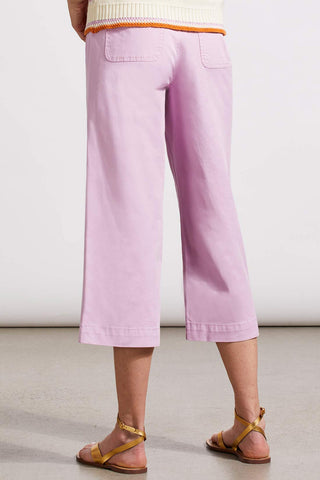  A model wearing wide leg crop jeans in an orchid color with double button pockets. The model paired the jeans with a colorful embroidered top.