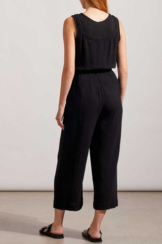 A sleeveless black jumpsuit with button-front bodice, tank top straps, and patch pockets, worn by a model standing against a light background.
